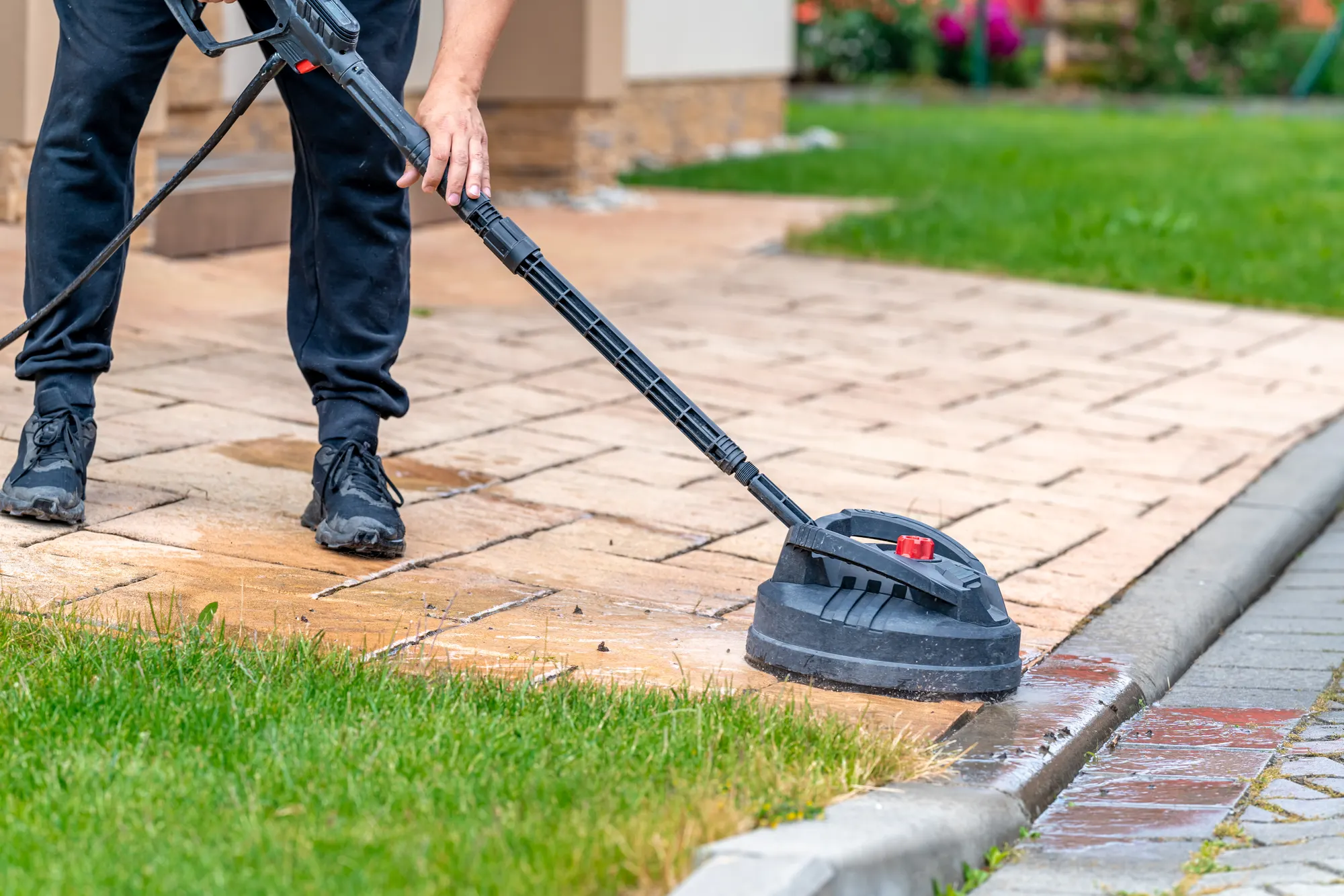 A surface cleaner mid-pass, carving a bright clean arc through years of dark grime